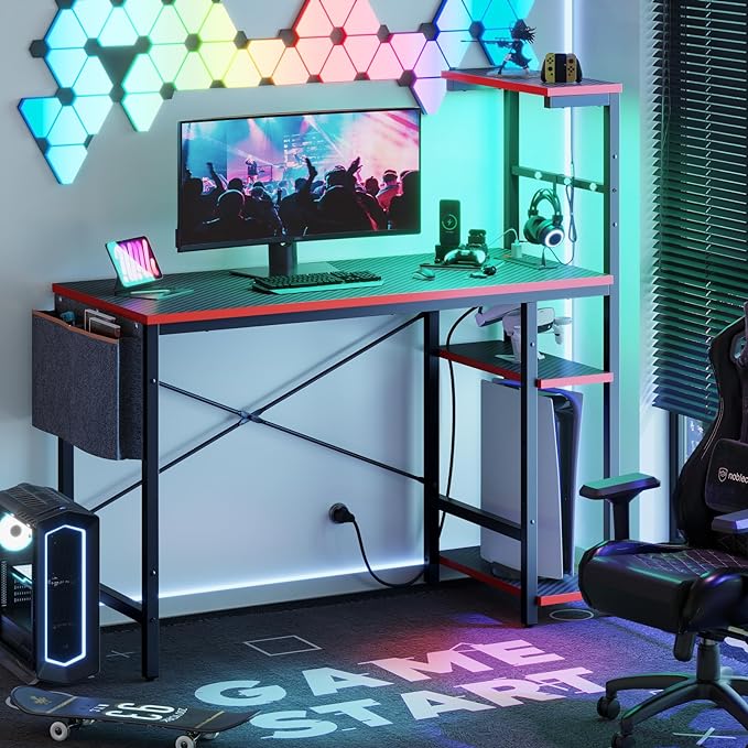 Bestier Gaming Desk with Power Outlets, 44 Inch Led Gamer Desk with 4 Tiers Reversible Shelves, PC Gaming Table with Headset Hook & Side Storage Bag for Bedroom (Black 3D Carbon Fiber) - LeafyLoom